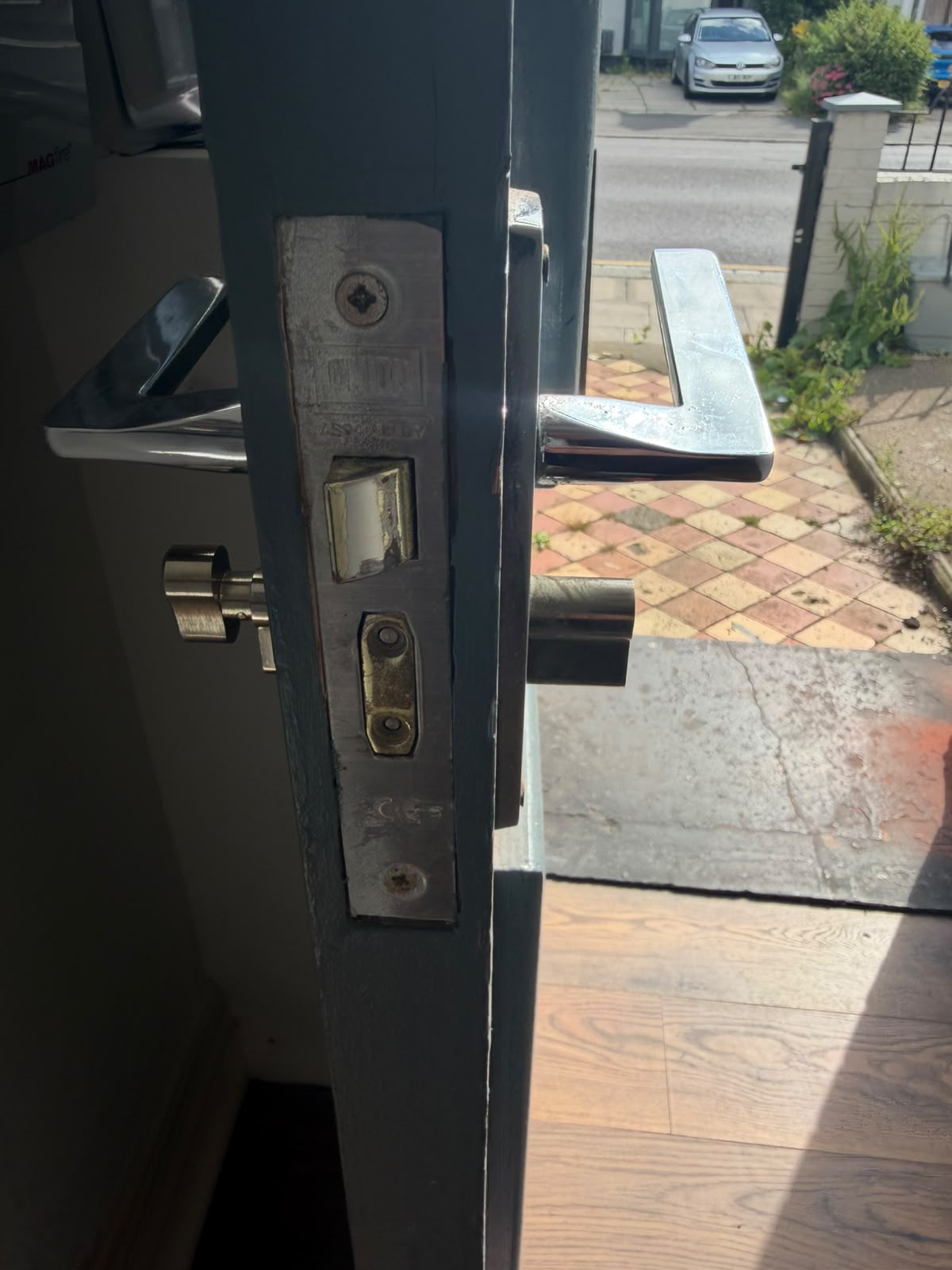 Oversized euro-cylinder protruding from a painted front door mortice lock, leaving it vulnerable to snapping
