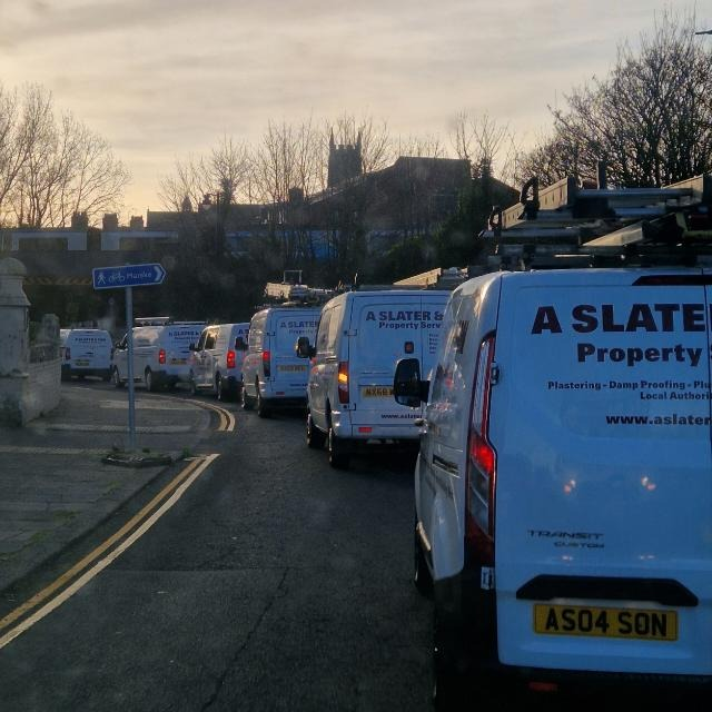 A convoy of A Slater & Son vans on a Middlesbrough street at sunrise