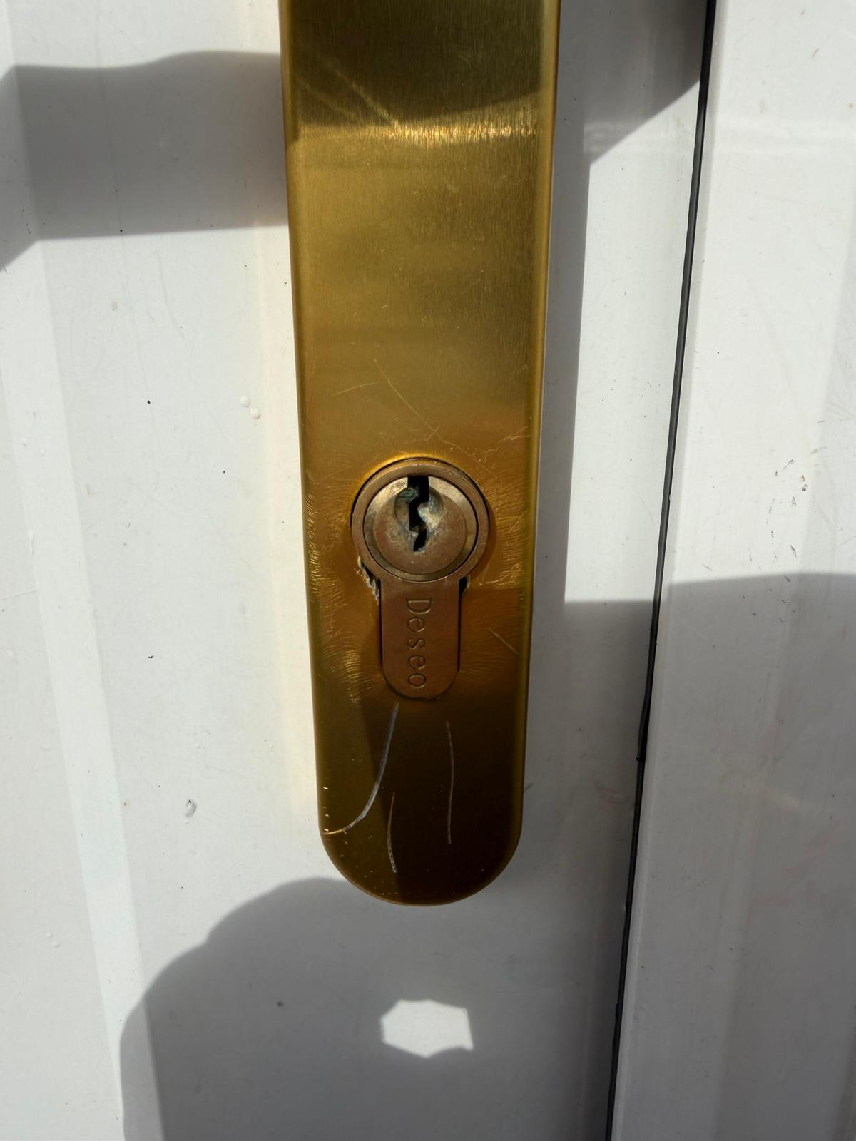 Worn brass euro-cylinder on a white uPVC front door before lock change after a young mother was locked out in Middlesbrough